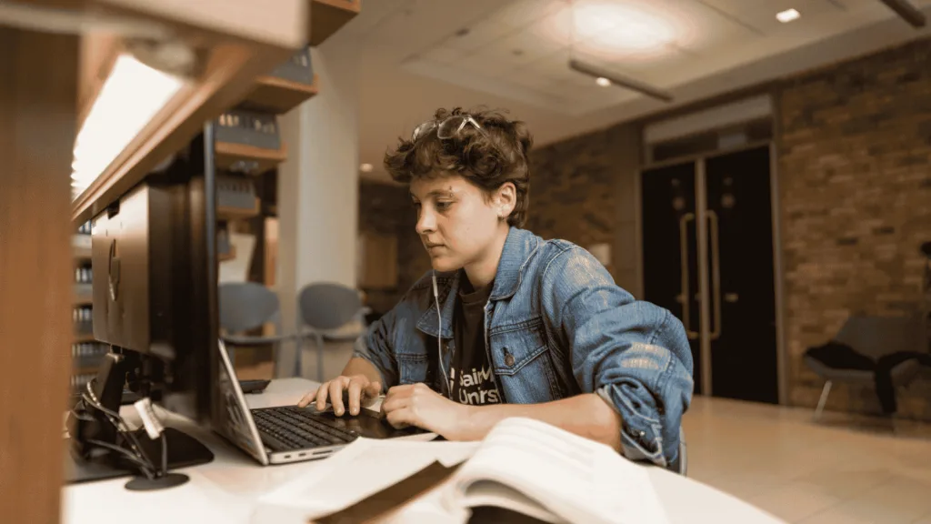 Person studying at a library computer desk