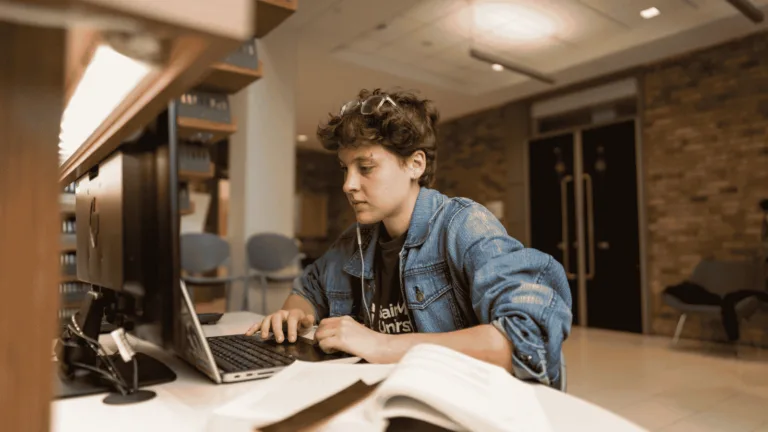 Person studying at a library computer desk