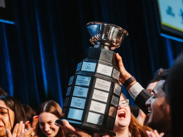 Group celebrating with large silver trophy.