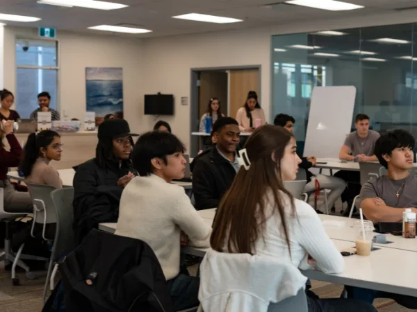 Diverse students attentively listening in classroom Setting.