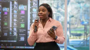 Person speaking into microphone, holding phone.
