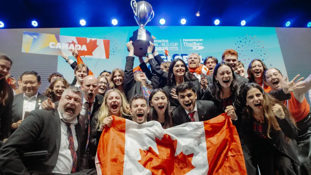 Cheering group with trophy and Canada flag.