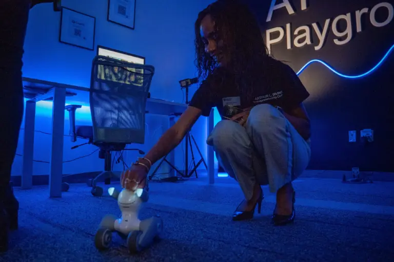 Person interacts with robot dog in AI lab.