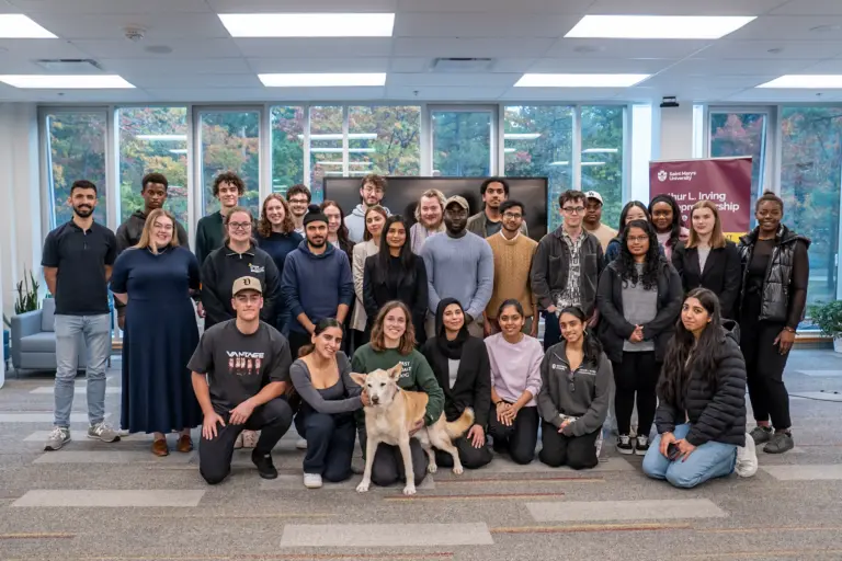Diverse group of students with dog inside a building.