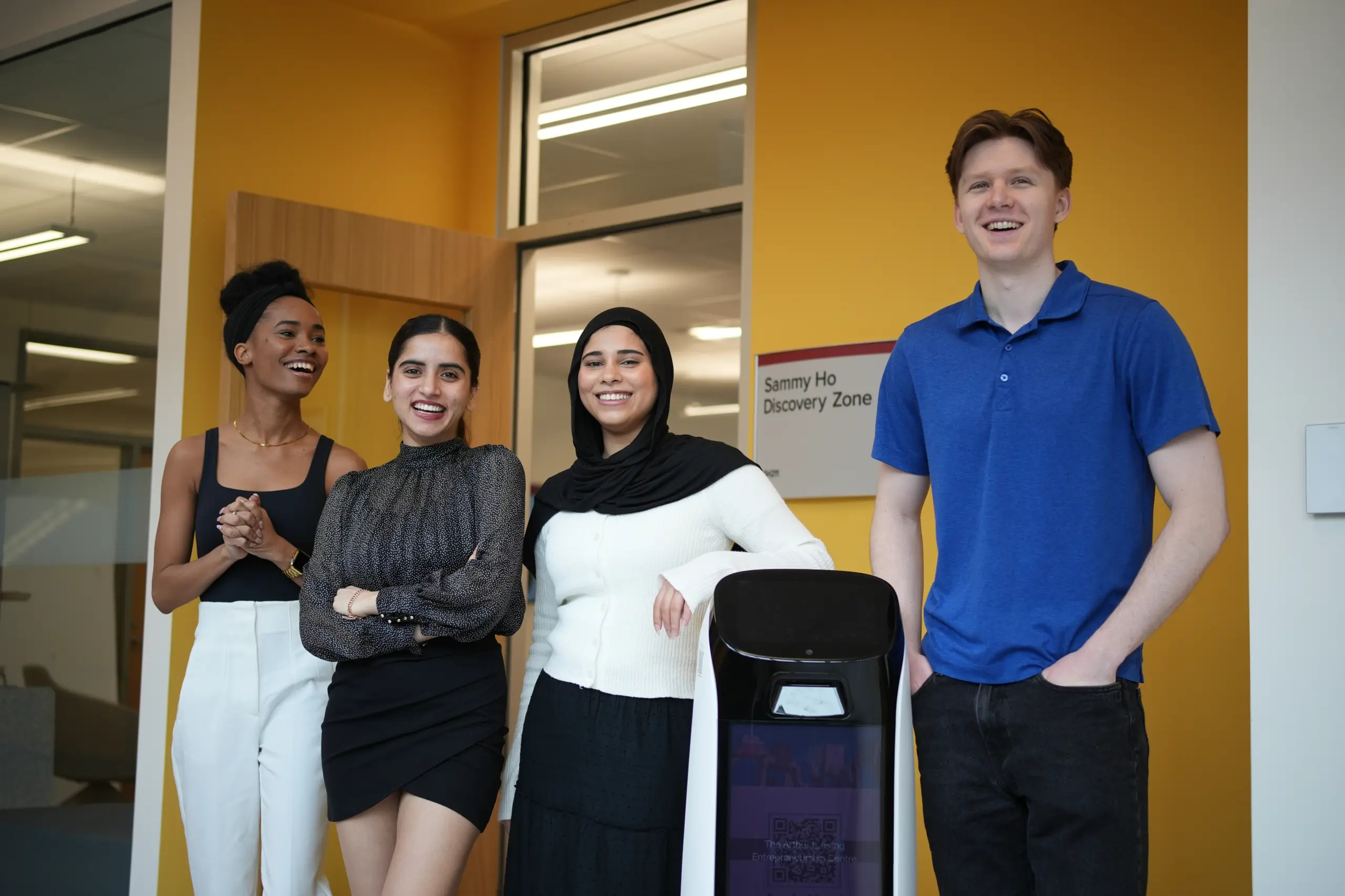Four people smiling in community space.