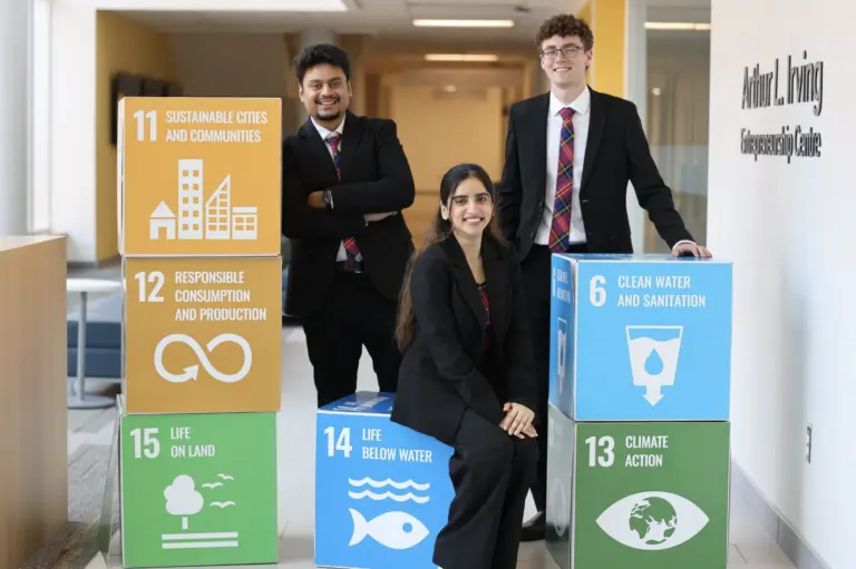 Three people with sustainable development goal blocks.