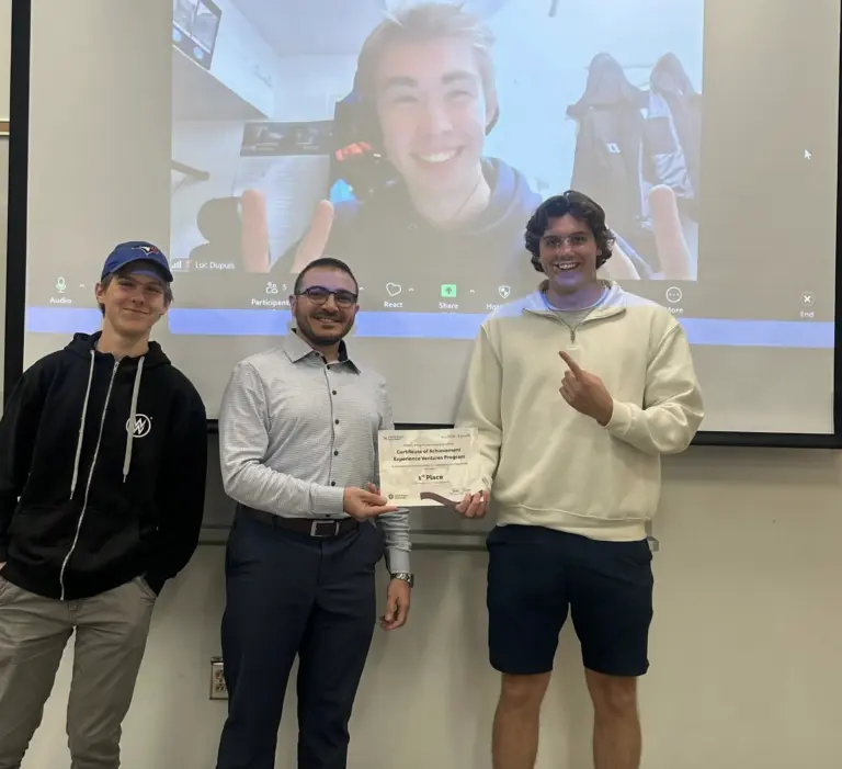 Three people smiling with a certificate.