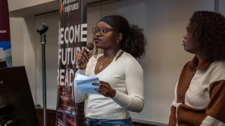 Woman speaking at microphone during presentation.