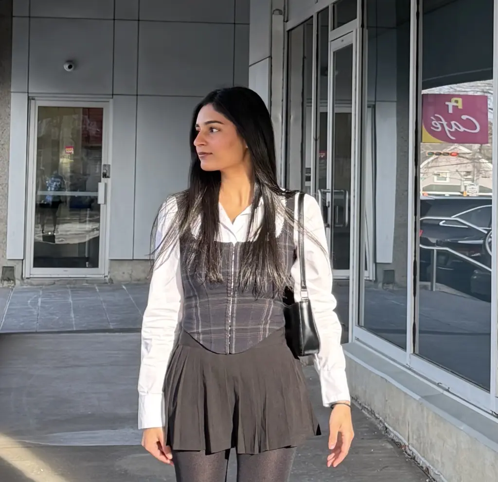 Woman in stylish outfit outside modern building.