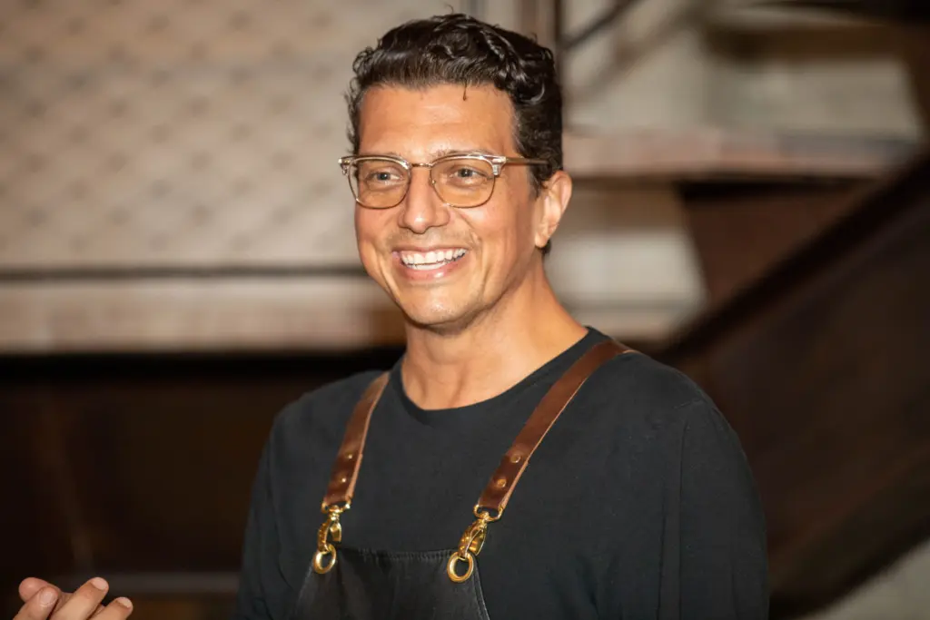 Smiling man wearing glasses and apron