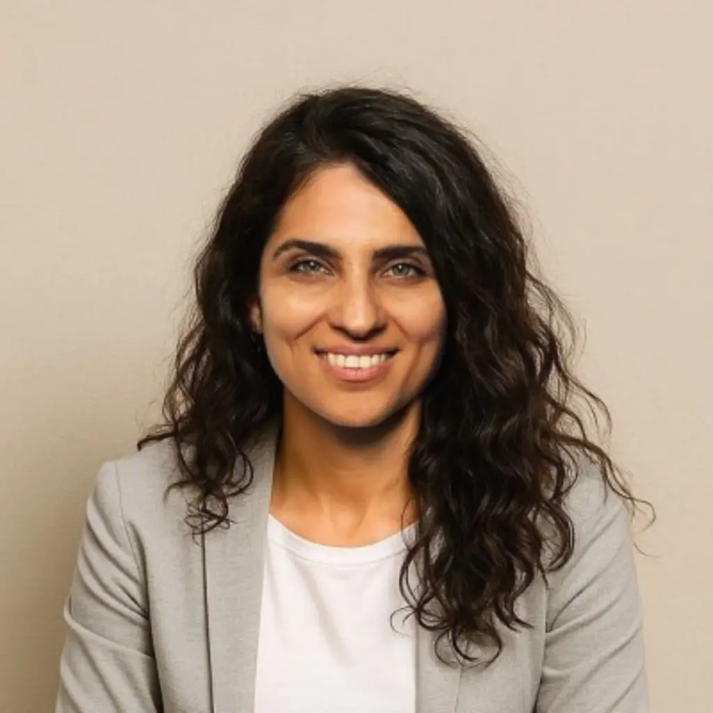 Smiling woman with curly hair in gray blazer
