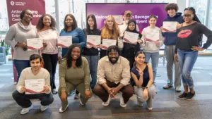 Students holding certificates at university recognition event