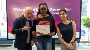 Three people at recognition event holding certificate