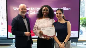 Three people holding certificate at recognition event