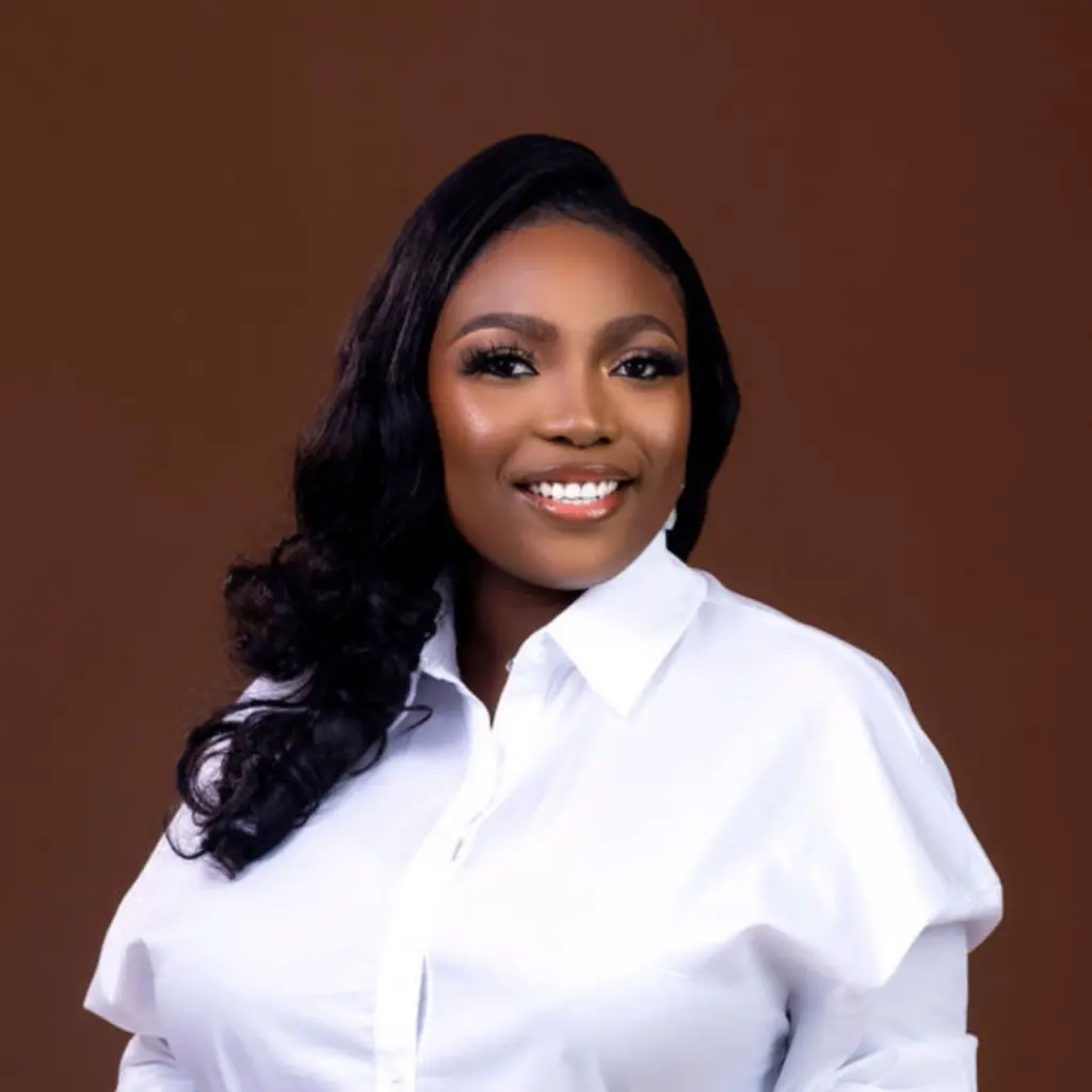 Smiling woman in white blouse against brown background