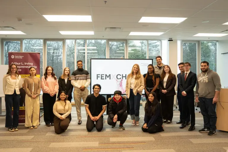 Group of students posing in classroom presentation setting