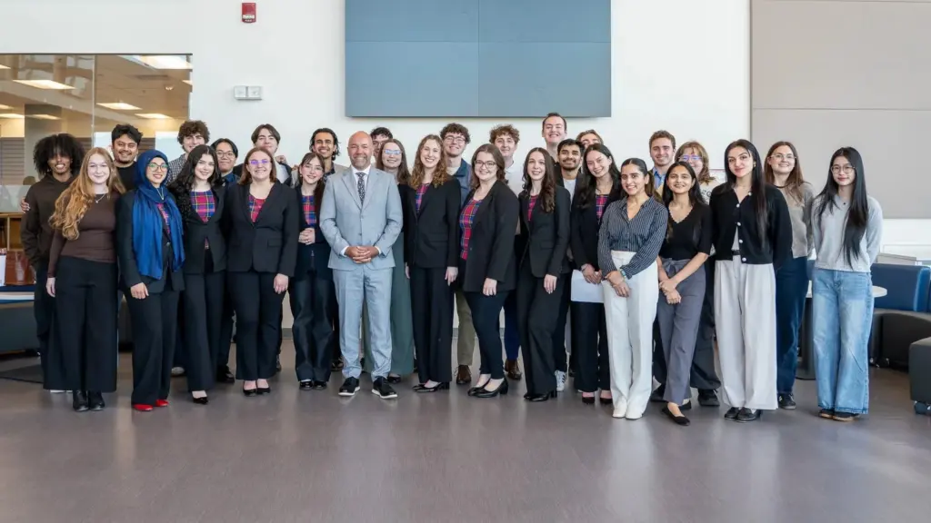 Diverse group posing indoors with suited man