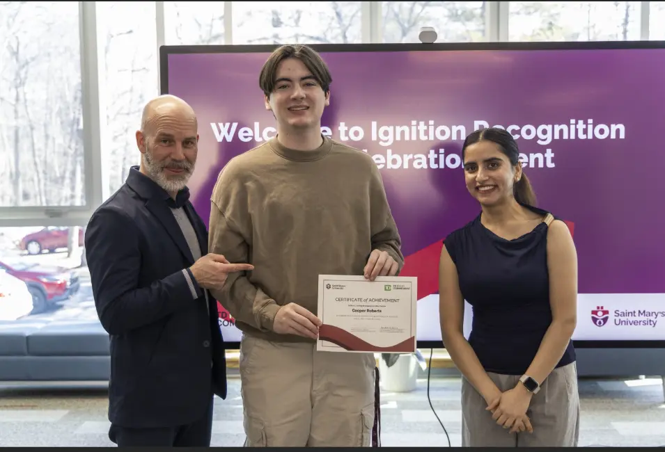 Three people holding certificate at recognition event