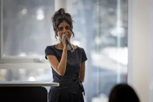 Woman speaking into microphone at indoor event