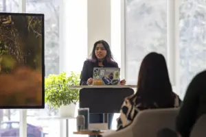 Woman presenting with laptop in bright meeting room