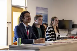 Three students listening during classroom discussion
