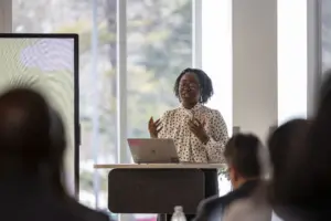 Woman presenting at podium with laptop