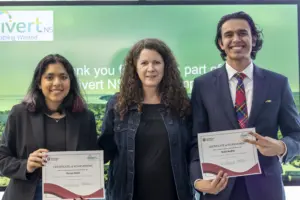 Three people holding certificates at award ceremony
