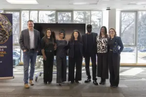 Seven professionals posing in modern office space
