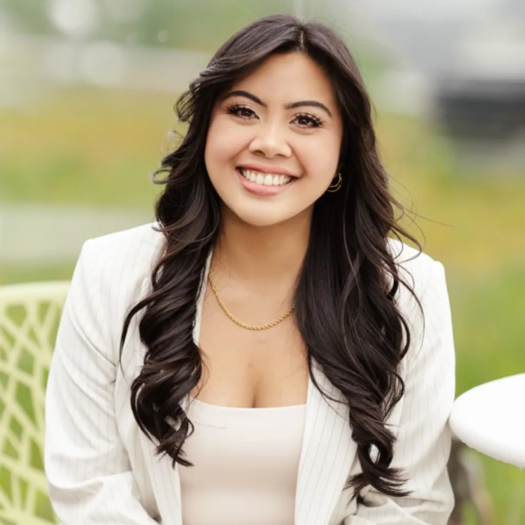 Smiling woman in white blazer outdoors