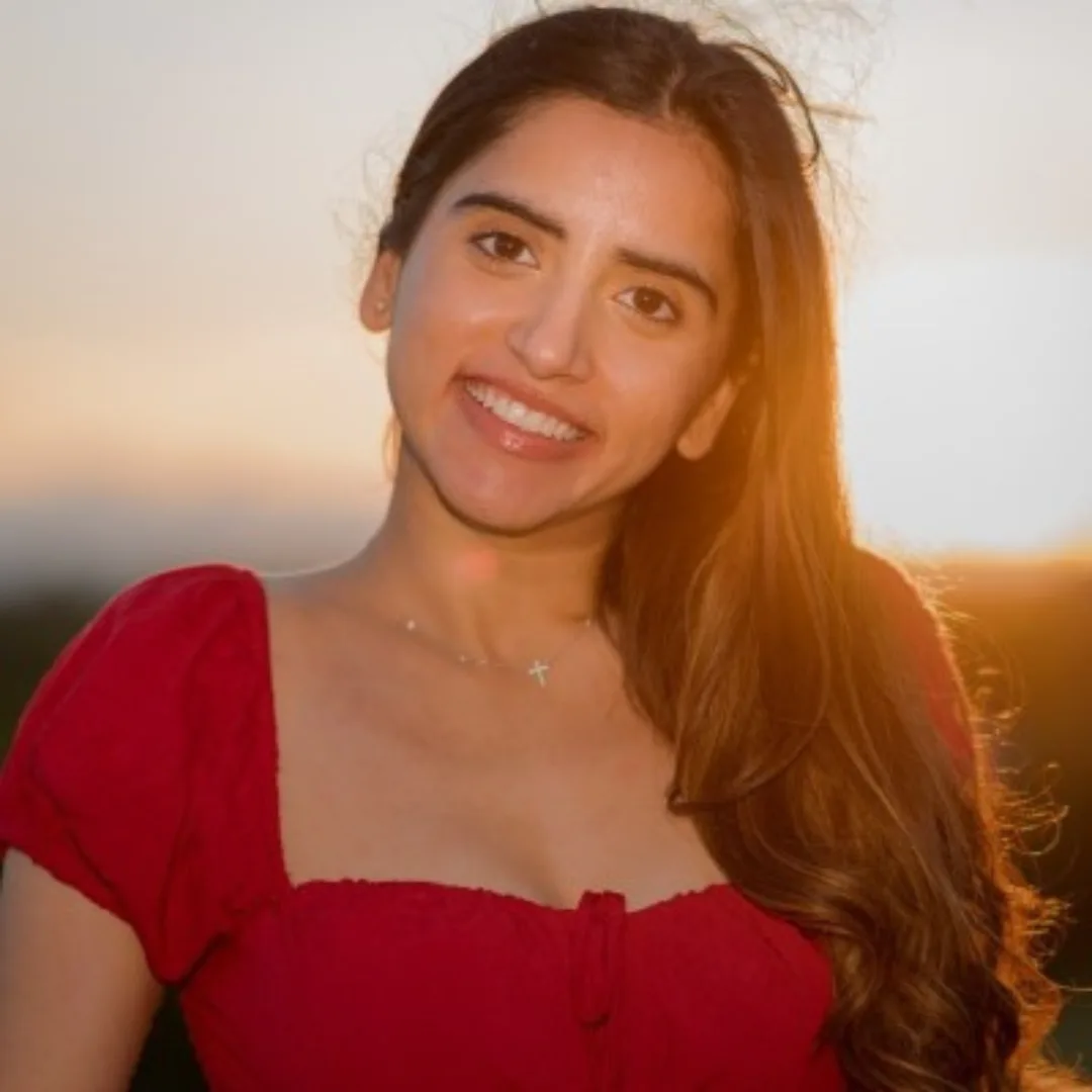Smiling woman in red dress at sunset