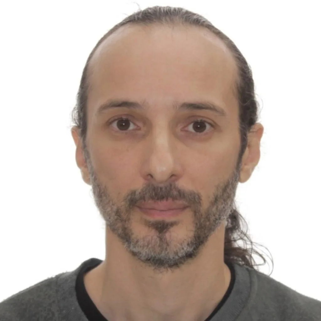 Headshot of a man with long tied-back hair