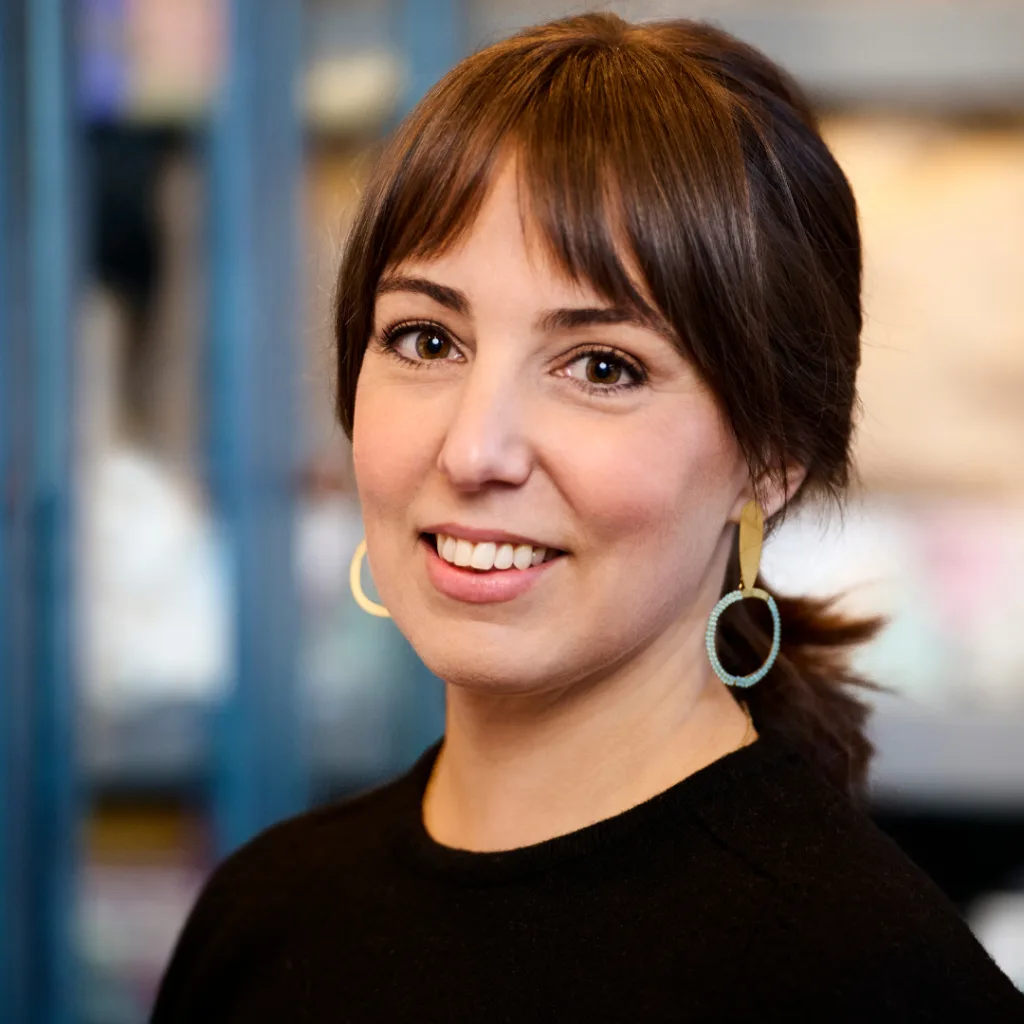 Smiling woman with brown hair and statement earrings