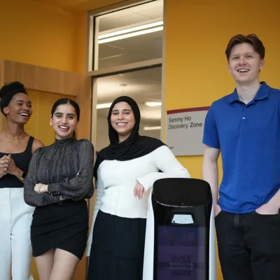 Four people smiling in community space.